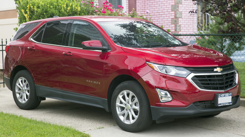 A front 3/4 shot of a Cajun Red 2019 Chevrolet Equinox parked in driveway