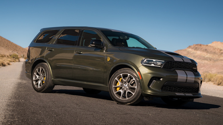 A front 3/4 view of a 2026 Dodge Durango SRT Hellcat Jailbreak parked diagonally on unmarked pavement between hills
