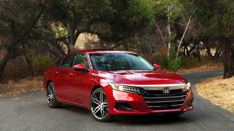 Front shot of a red 2026 Honda Accord Hybrid on a scenic road