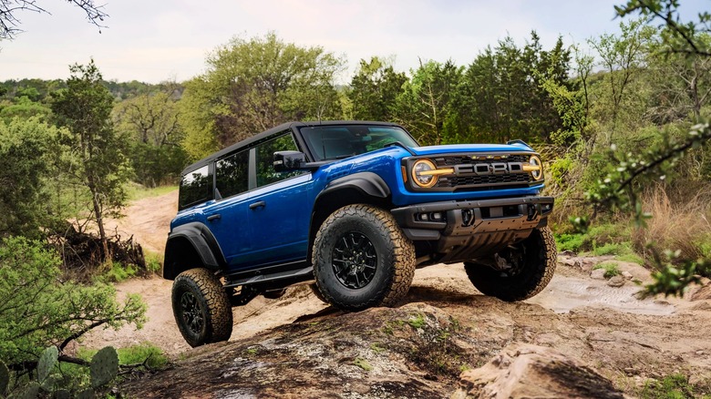 Front 3/4 of a blue Ford Bronco off-roading.