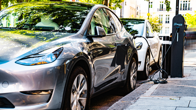 A Tesla EV plugged in at a public charger.