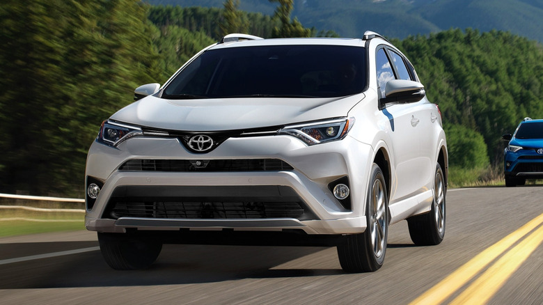 Front action shot of a white 2018 Toyota RAV4 SE Hybrid.