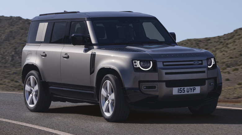 2025 Land Rover Defender 110 driving on a curved hilly road