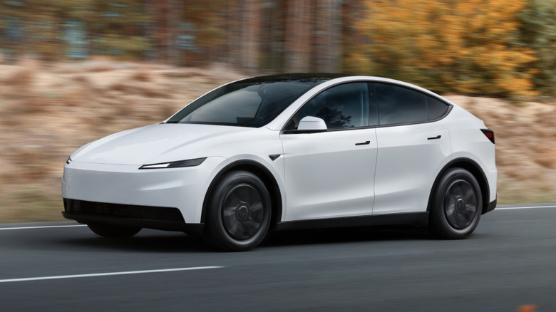 A white Tesla Model Y driving on a road