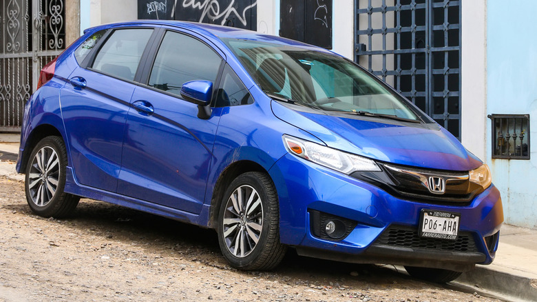 Blue Honda Fit parked on the street.