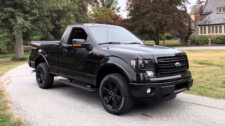 A black Ford F-150 Tremor sits in a fancy driveway with a menacing look.