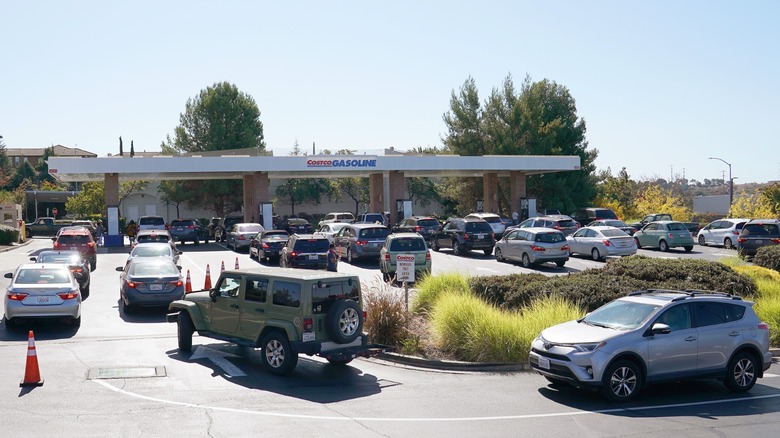 Dozens of cars create long lines at a Costco gas station.