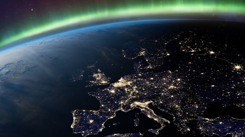 The Aurora Borealis visible in Earth's atmosphere over Europe lit up with city lights