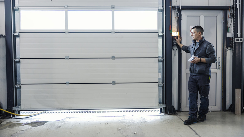 Man using automatic garage door opener to slightly open his garage door