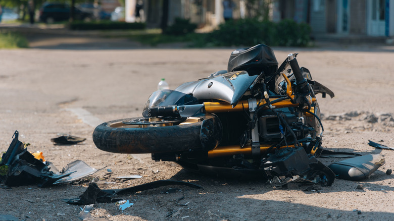 A damaged motorcycle resting on the ground after a crash.