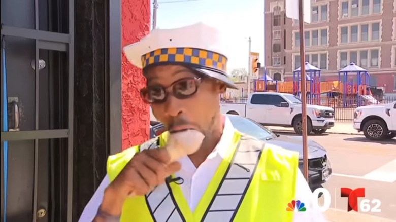 Crossing guard Jamele Ransom takes a bite of an ice cream cone during his interview with reporters about a crash into a local Philadelphia playground on May 5.
