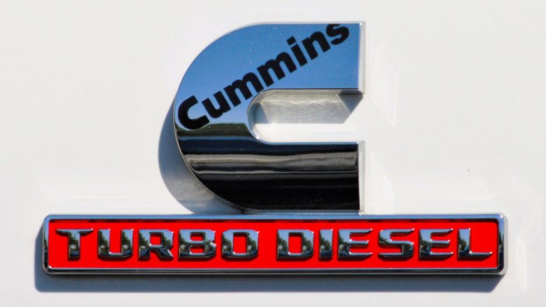 A closeup of the Cummins Turbo Diesel logo on a white Ram pickup truck