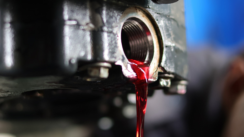 Red automatic transmission fluid draining from a transmission.