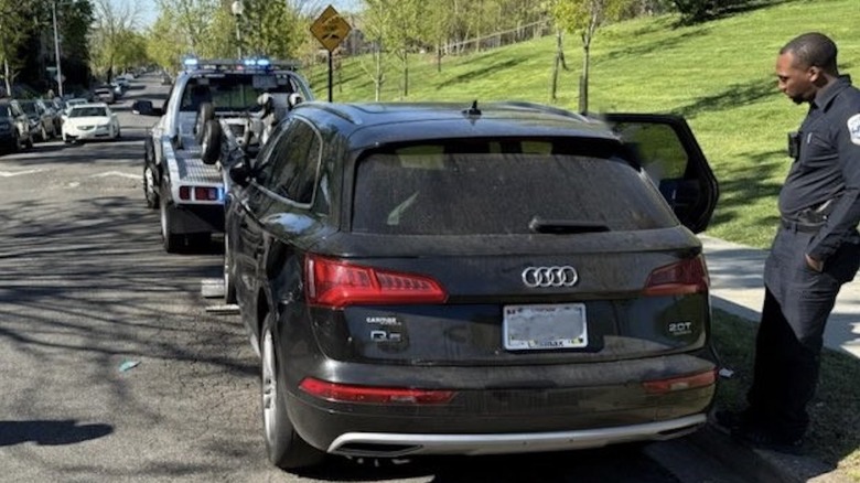 A black Audi Q5 being towed from the side of a D.C. street.