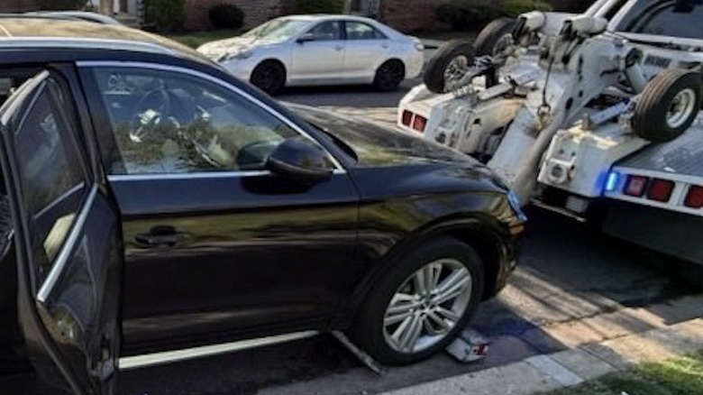 A black Audi Q5 being towed from the side of a D.C. street.