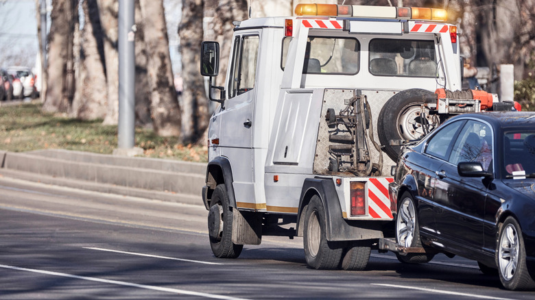 Tow truck carrying improperly parked car or repossessed vehicle.  by: AstroStar