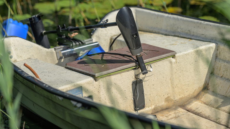 A trolling motor hooked up to a boat, presumably as its sole source of propulsion and powered by a deep cycle battery.