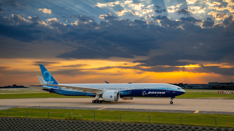 A Boeing 737 seen from the side on a runway at sunset