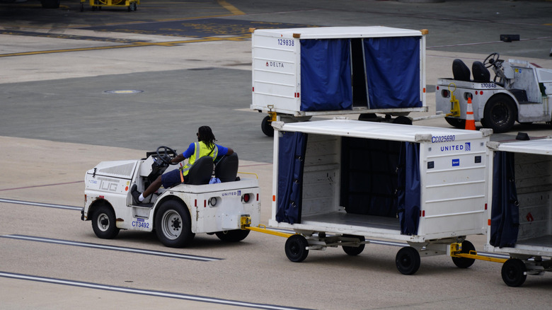 Morrisville, North Carolina - August 16 2026: Airport Baggage Cart Driving Along A Concourse On The Airport Tarmac
