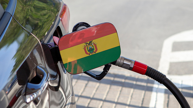 A Bolivian flag on the gas cap of a car filling up
