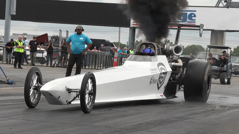 Front view of a diesel dragster doing a burn out