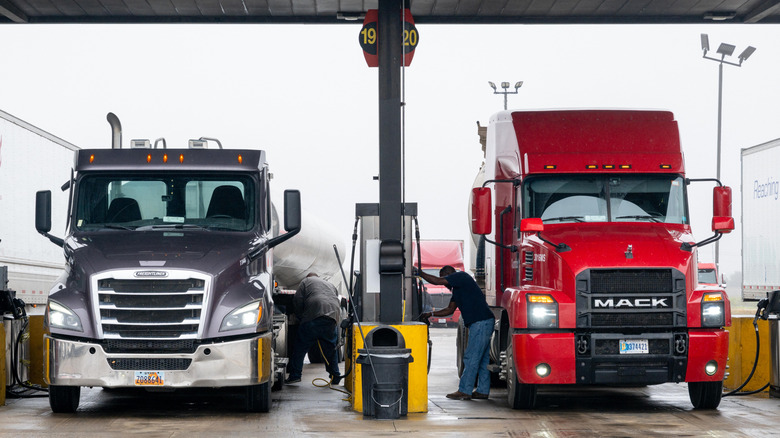 Front view of two semi-trucks refueling at a truck stop