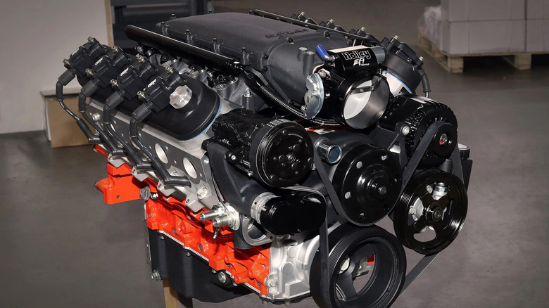 A modified GM LS engine featuring a single camshaft that's either a roller or flat-tappet setup, sporting an orange block and many aftermarket performance parts.