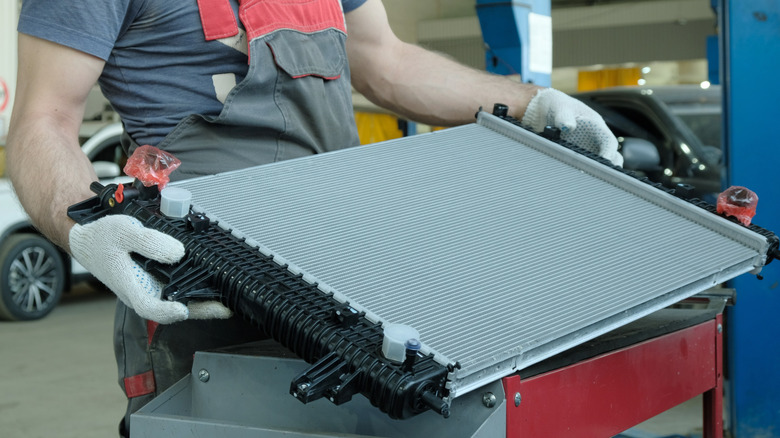 A technician inspects a new radiator prior to installing it.