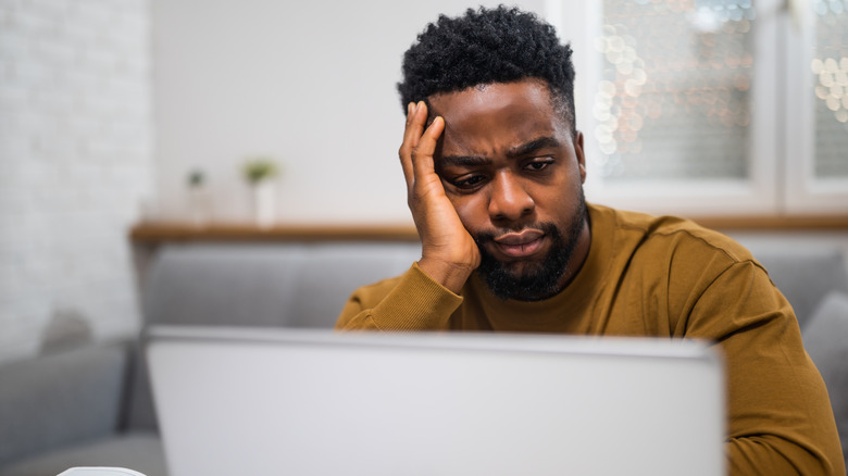 A man puzzles over a computer screen.