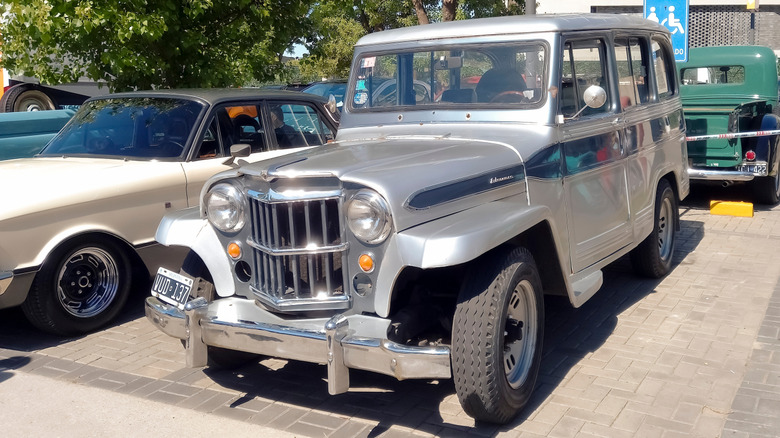 A silver and blue first-gen Jeep Wagoneer parked outside