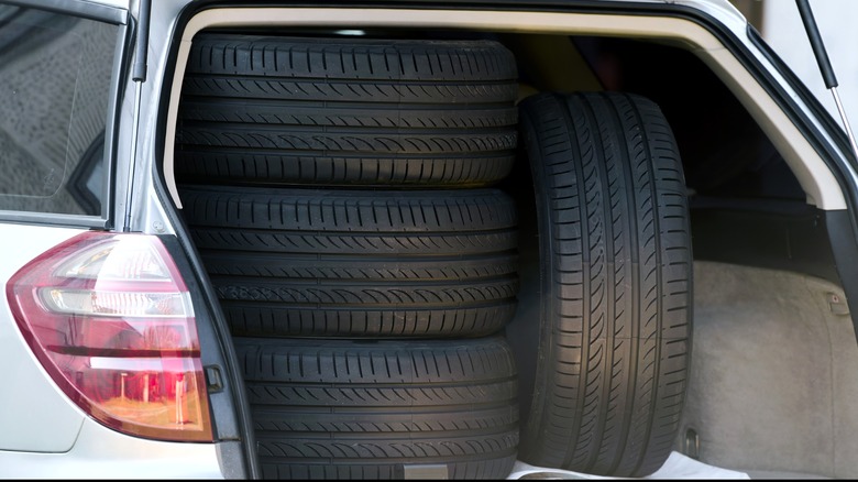 A set of new tires packed in the truck of a crossover SUV