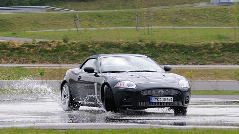 A Jaguar XK convertible oversteering in wet