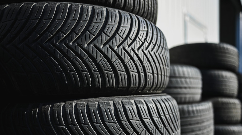 A stack of used car tires inside a garage