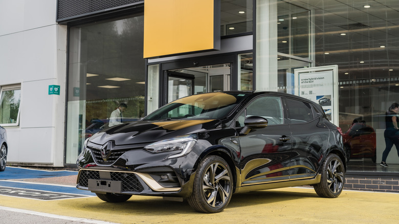 Black Renault Clio parked outside of dealership.