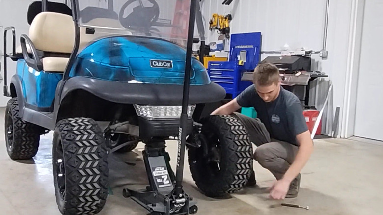 A mechanic fixing a golf cart