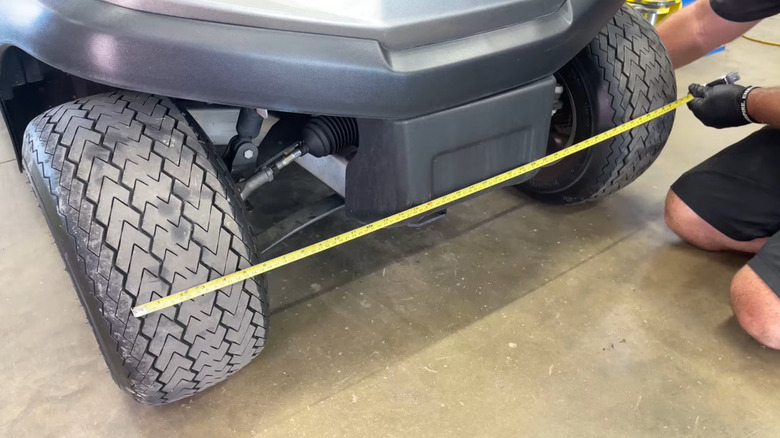 Mechanic measuring the toe difference of a golf cart