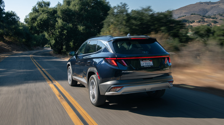 Rear 3/4 view of a blue 2026 Hyundai Tucson Hybrid.