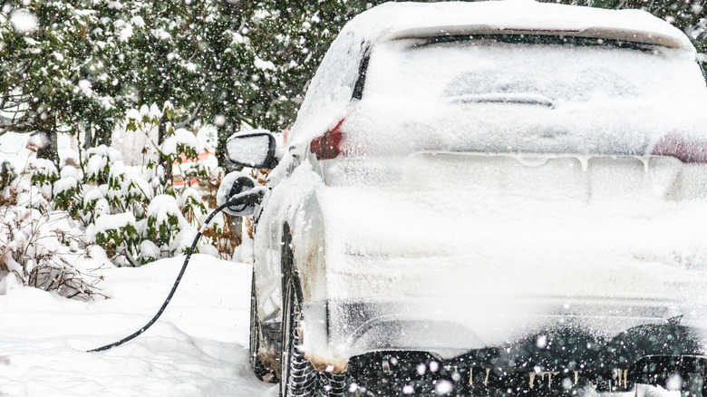 A Chevrolet Bolt EV being charged in the snow.