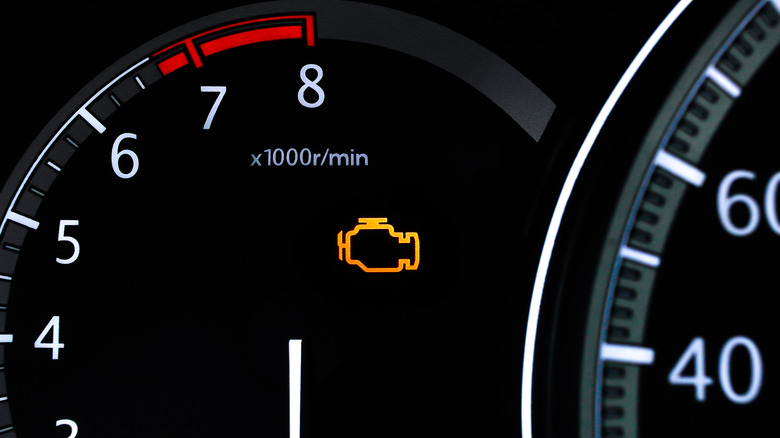 An illuminated check engine light on a car's instrument panel.