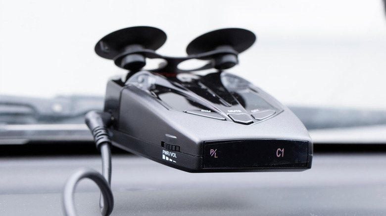 A radar detector mounted on a car's windshield.