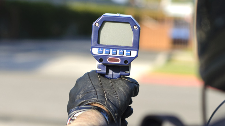 A police officer holding a radar gun.