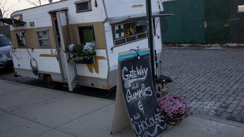 A pop-up cannabis dispensary advertises some of its products, sold out of a mobile camper van