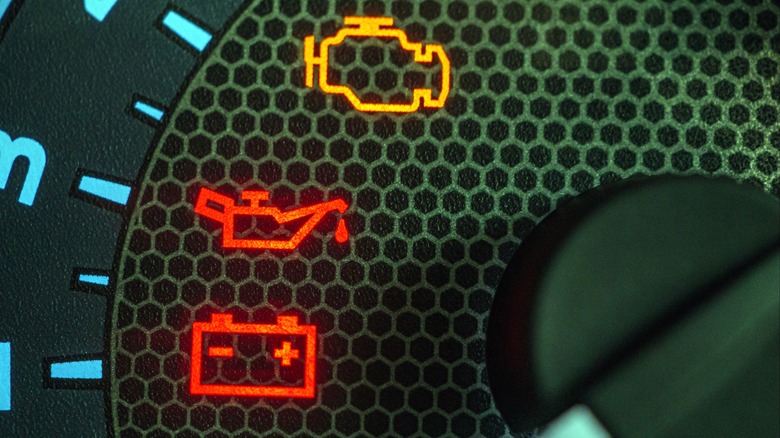 A car's gauge cluster showing warning lights for check engine, oil, and battery charging.