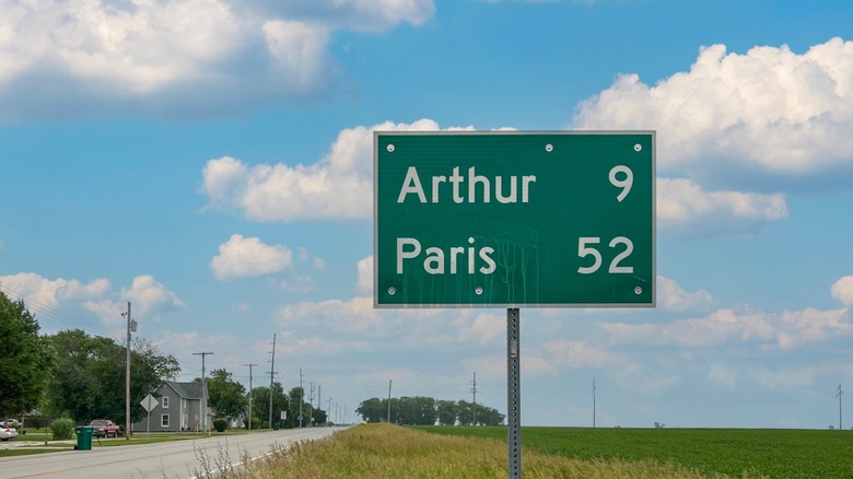 An Illinois highway sign showing nine miles to Arthur and 52 miles to Paris.