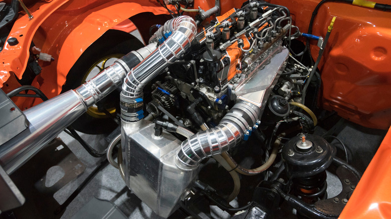 A massive air-to-water intercooler living under the hood of an orange drag car.