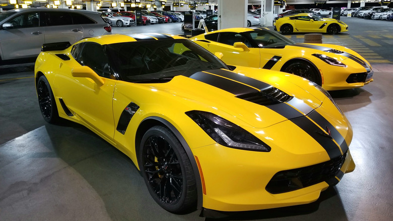 Several yellow C7 Corvettes displayed for rent at Hertz parking garage