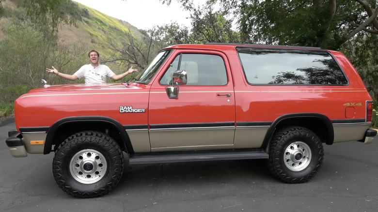 Doug demuro stands besides a dodge ramcharger