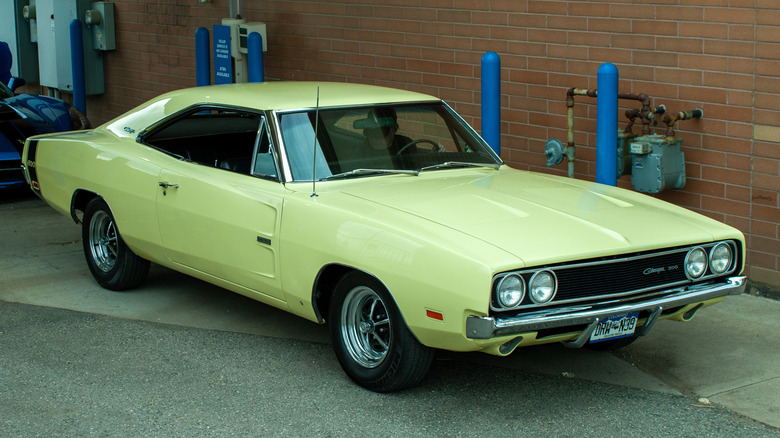 A second generation dodge charger parked in an alley, bright yellow