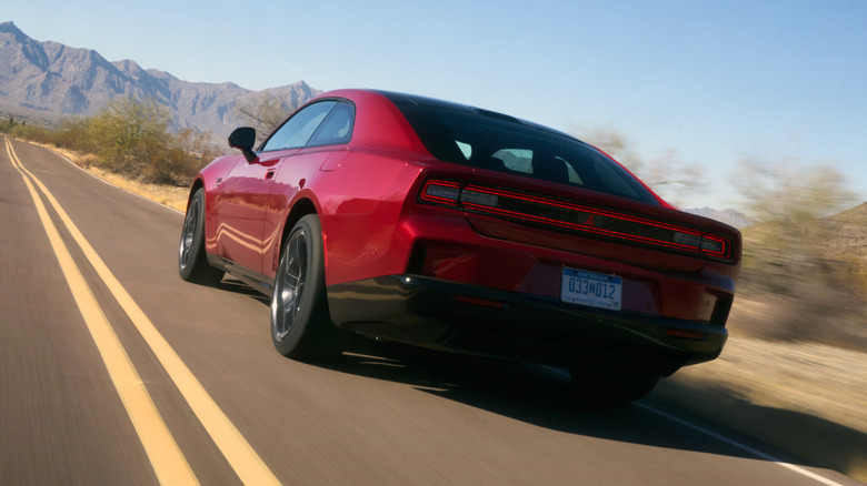 Rear 3/4 view of a Dodge Charger Daytona driving down a straight desert road