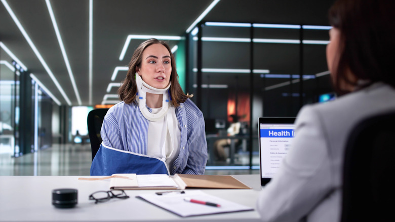 An injured person filling a claim in an office.